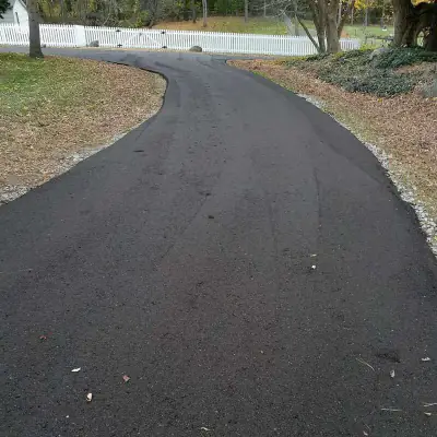 Long driveway beside a white rail fence