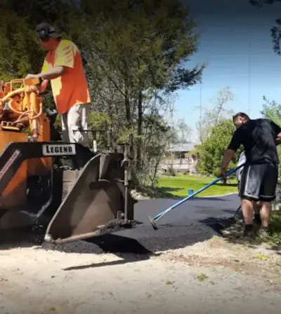Crew laying hot mix behind the paver